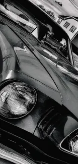 Black and white vintage car close-up with cloudy sky.