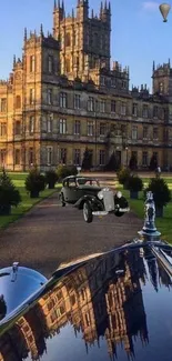 Vintage car reflecting grand castle on a sunny day.