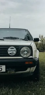 A vintage car parked in a serene countryside setting.