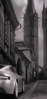 Monochrome image of a vintage car on a gothic street with tall towers.