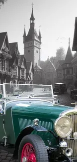 Vintage green car on European cobblestone street with old buildings.