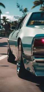 Vintage turquoise car on tropical road with palm trees.