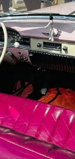 Vintage car with pink interior and classic dashboard.