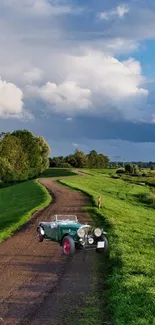 Vintage car on a scenic, winding country road under a blue sky.