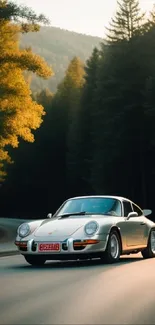 White vintage car on a winding forest road at sunset.