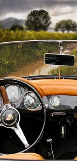 Interior of a vintage car with a scenic road view through the windshield.