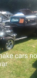 Vintage car show featuring a black hot rod on green grass.