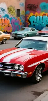 A red vintage car in front of vibrant street art graffiti.