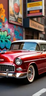 Vintage red car parked against graffiti-covered urban wall.