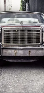 Vintage car front view with classic grill in urban setting.