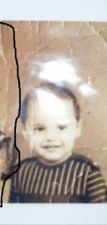 Vintage sepia portrait of a smiling child in striped outfit.