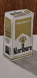 Vintage cigarette pack with artistic design and shadowing on a wooden background.