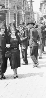 Black and white vintage street scene with elegantly dressed people.