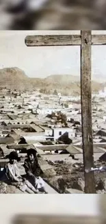 Sepia-toned cityscape with a large cross in the foreground.