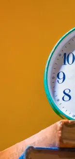 Vintage clock on books with mustard yellow background.