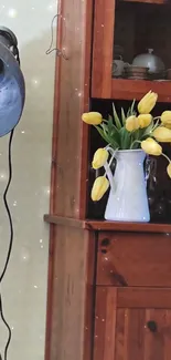 Rustic cabinet with yellow tulips in vase and vintage lamp.