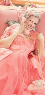 Woman in coral vintage dress with retro phone, lying on bed.