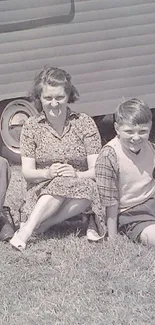 Vintage family photo with caravan backdrop in grayscale.