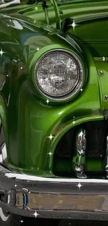 Close-up of vintage green car front with chrome details.