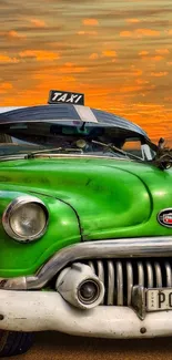 Vintage green taxi against a vivid sunset sky.