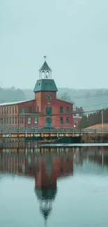 Vintage brick building reflecting on a calm lake.