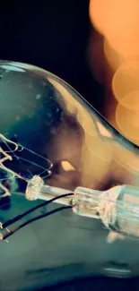 Close-up of a vintage light bulb with bokeh lights in warm hues.