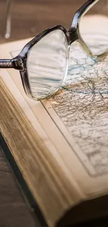 Vintage map with glasses on an open book, perfect for travel lovers.