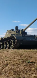 Vintage military tank on grass with blue sky background.