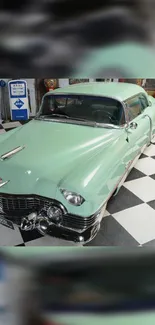 Vintage mint green car with classic design on checkerboard floor.