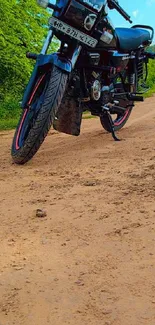 Vintage motorcycle on a dirt road with lush greenery background.