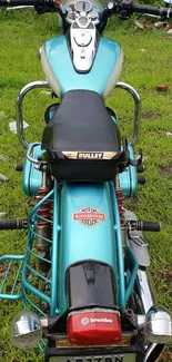 Vintage turquoise motorcycle on grass background.