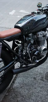 Vintage black motorcycle parked on roadside, showcasing sleek design.