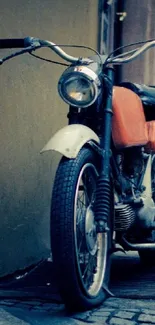 Vintage motorcycle on cobblestone street in an urban setting.