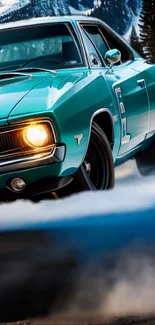 Teal vintage muscle car racing through a scenic mountain road with headlights on.