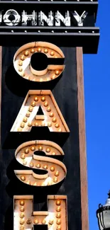 Vintage neon sign against blue sky background.