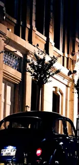 Vintage car parked on illuminated street at night.