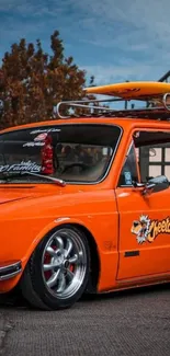 Vintage orange car with surfboard.