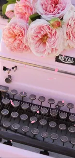 Vintage pink typewriter with flowers on top, creating a charming look.