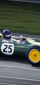 Vintage green race car speeding on track with yellow wheels.