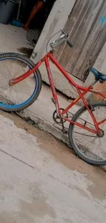 Vintage red bicycle against a rustic wall background wallpaper.