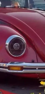 Close-up of vintage red car fender with chrome details.