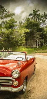 Vintage red convertible car on a scenic road.