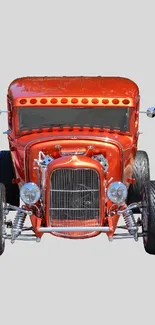 A bold red vintage hot rod car on a gray background.