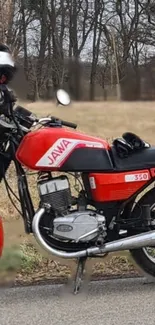 Vintage red motorcycle parked on a road with a natural background.