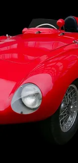 Vintage red sports car on a black background.