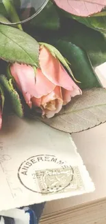 Vintage wallpaper with pink roses and old letter on book.