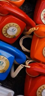 Colorful vintage rotary phones clustered together.