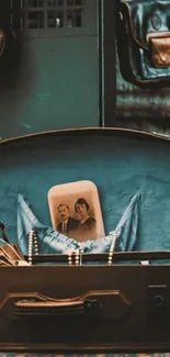 Open suitcase with old photo in teal vintage setting.