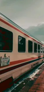 Vintage train on a platform under a moody sky.