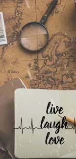 Vintage travel essentials on a map with 'live laugh love' notebook.